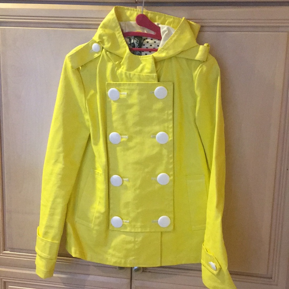 Bright yellow rain coat with white buttons.
